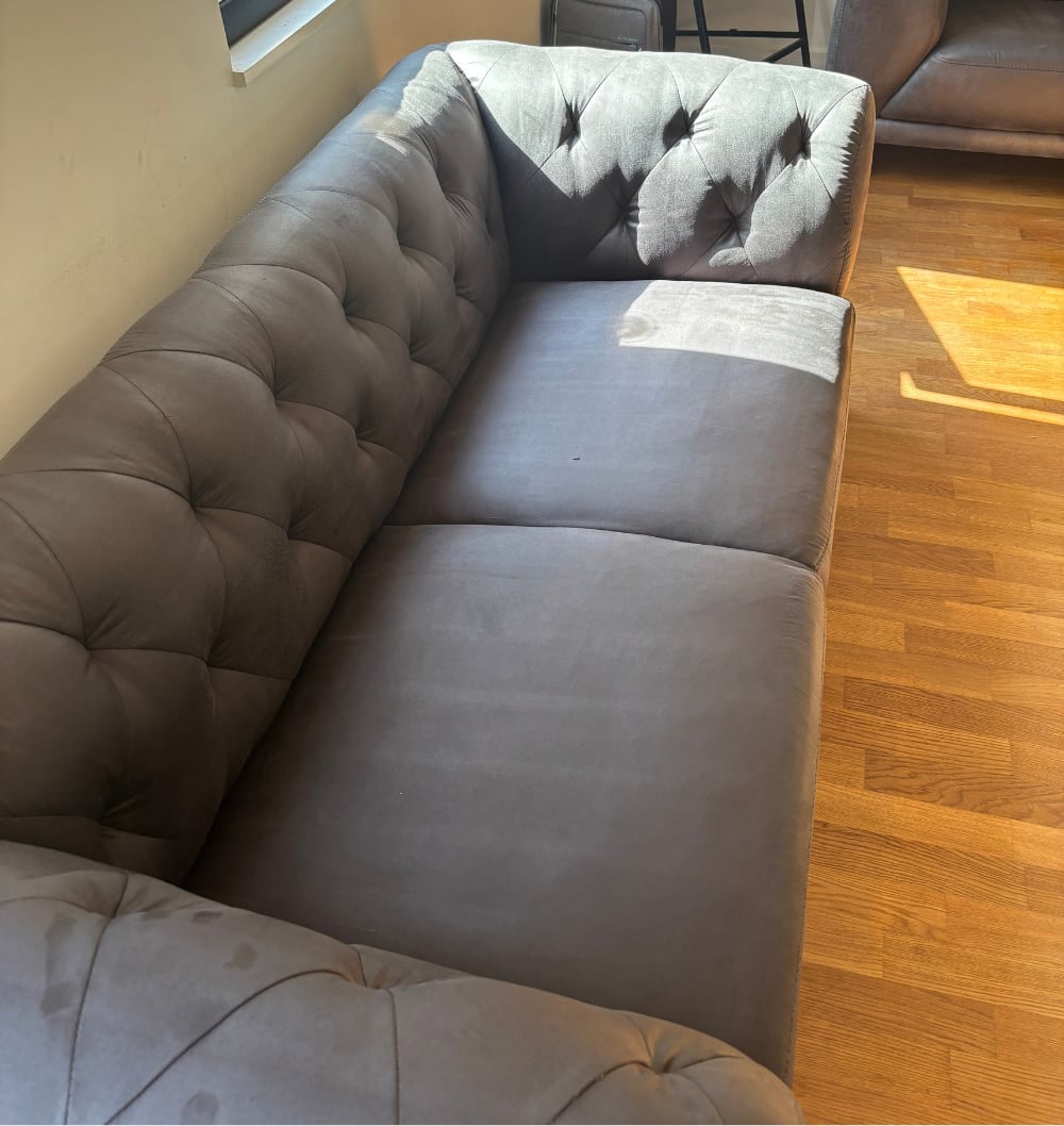 Grijze fluwelen Chesterfield-zetel na de reiniging in Overijse